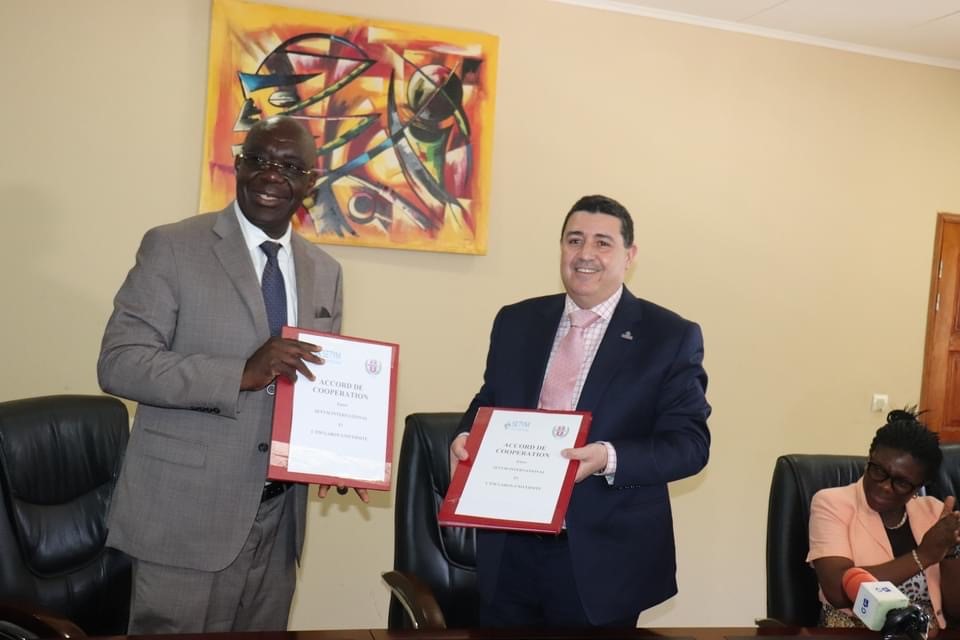 Larbi Bennouna, PDG de SETYM accompagné du Professeur Franck Idiata, directeur de l’EM Gabon-Université tenant fièrement l'accord de partenariat signé. Les hommes sont souriants.